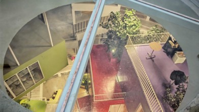 View of the colorful, modern courtyard of a building with plants and different levels, Tirana,