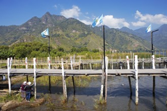 Guatemalan people wearing traditional clothing on a wooden pier in the port of San Juan la Laguna,
