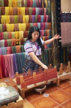 Maya woman, 42 years old, places cotton in a weaving frame, traditional craft in a woman's