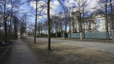 Promenade along the Reichstag with trees and sidewalk on a sunny day, deserted, without people,