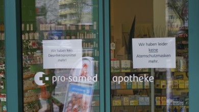 Pharmacy entrance with signs about missing disinfectants and protective masks, during corona,