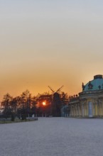 Sunset behind trees with windmill and baroque building in the foreground, Potsdam