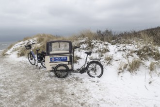 Police bike in snowy dunes, Langeoog, Lower Saxony, Germany