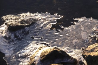 Ice on a lake near stones, winter, Germany