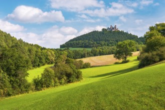 View over green meadows and forests to the ruins of Hanstein Castle, Bornhagen, Eichsfeld,