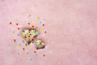 Two heart-shaped baking pans and sugar confetti