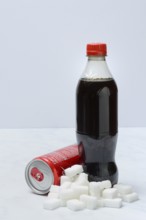 Cola drink in bottle and can, lots of sugar cubes