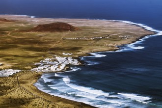 Coastal village of Caleta de Famara on a winding coast with waves and sweeping skies, Mirador de