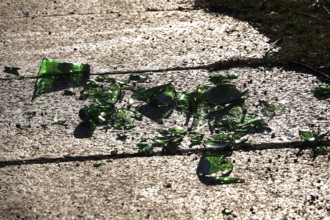 Broken glass on a sidewalk, danger to passers-by, cyclists and animals, Germany