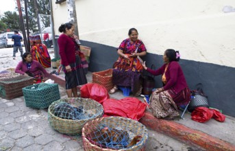 Mayan woman wearing traditional clothing sell chickens on the street in Chichicastenango,