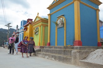 Mayan woman wearing traditional clothing at colorful graves at the cemetery in Chichicastenango,