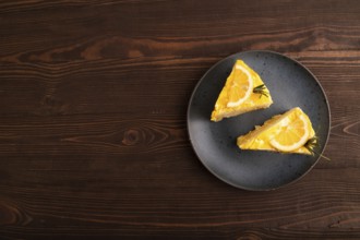 Lemon cake on brown wooden background, top view, flat lay, copy space