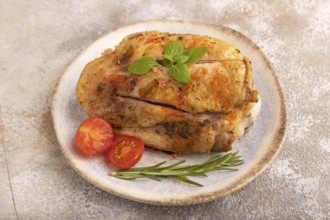 Fried Turkey Thigh with spices and rosemary on plate on brown concrete background. side view, close