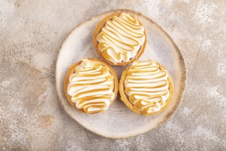 French lemon tart with meringue on brown concrete background, top view, flat lay, close up