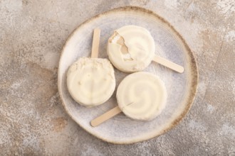 ?hocolate Ice cream in white glaze, on brown concrete background, top view, flat lay, close up,