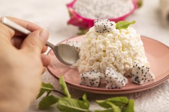 White ?ottage cheese, Curd, with Pithaya with hand on gray concrete background and linen textile,