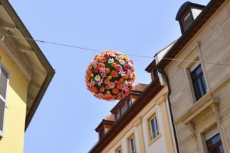 Ettlingen, Germany - August 13th 2025: Floral sphere of flowers hanging above street as summer