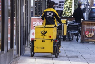 Deutsche Post mailman out and about with his bicycle. Stuttgart, Baden-Württemberg, Germany