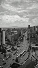 Bird's-eye view of an urban landscape in black and white, busy streets between skyscrapers
