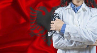 Healthcare professional with Albania flag background. Professional doctor holding stethoscope on