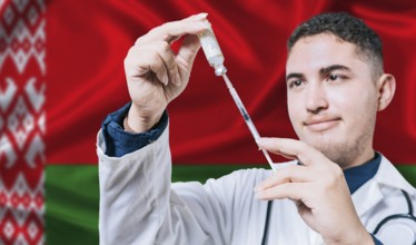 Doctor holding syringe on Belarus flag background. Medical professional holding syringe with