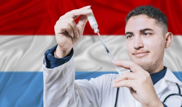 Doctor holding syringe on Luxembourg flag background. Medical professional holding syringe with