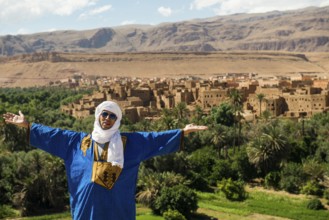 Traditionally dressed Berber and Allas Mountains in the background, near Merzouga, Meknès-Tafilalet