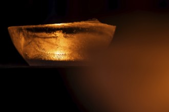 Ice bowl illuminated by a burning tea light, winter, Finland