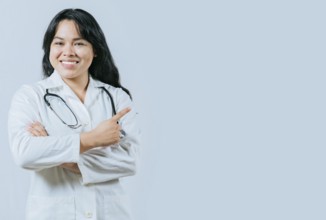 Smiling asian female doctor recommending an advertisement. Asian young doctor pointing to the side