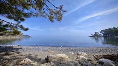 A peaceful pebble beach with a view of the calm sea and clear skies, Antalya, Turkey