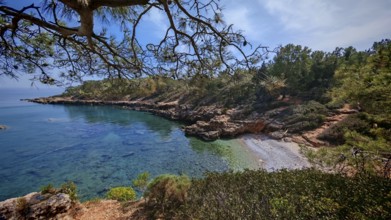 A quiet bay with clear water surrounded by rocky coastline and trees, Antalya, Turkey