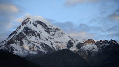 Majestic snow-covered mountain under cloudy sky, Kazbek, Stepantsminda, Georgia