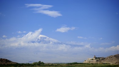 Extensive mountain landscape with a small monastery and cloudy sky, Khor Virap with Ararat in the