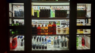 Diverse selection of liquor bottles on illuminated shelves, Prague, Czech Republic