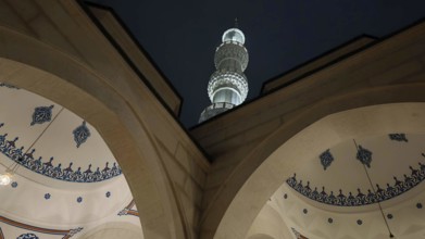 Night view of a mosque with minaret and ornamental arches, Tirana, Albania