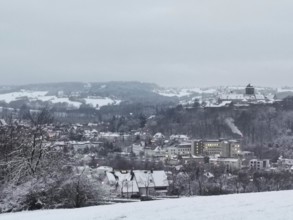 Snowy village on a hill with a view of the surrounding snow-covered landscape