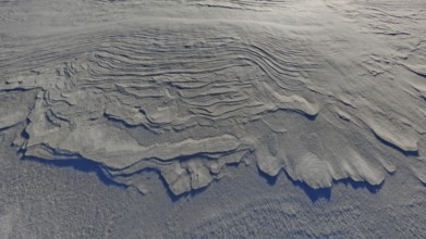 Close-up of wavy erosion patterns in sand