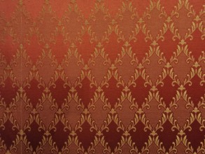 Red fabric with golden, ornamental damask pattern