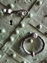Close-up of an old green door with metal handle and key opening