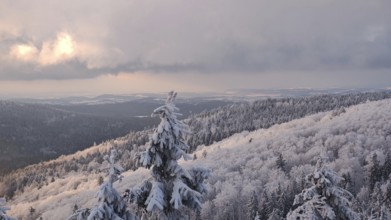Extensive winter landscape with forests and mountains under a dramatic sky, Fichtelgebirge, Bavaria