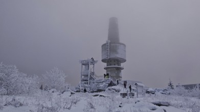 People in snowy surroundings with tower in fog as a central point, Backoefele on the Schneeberg,