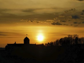 Silhouette of a castle in front of a glowing sunset