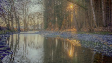 A calm river reflects sunlight surrounded by trees