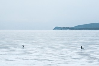 Lake Baikal, Siberia, Russia. People in the vast frozen lake in deep winter