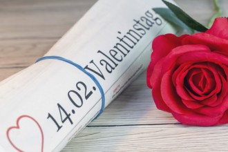 Symbolic newspaper with the title 14.02. VALENTINE'S DAY next to a red rose