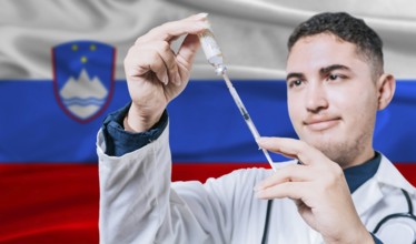 Doctor holding syringe on Slovenia flag background. Medical professional holding syringe with