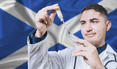 Doctor holding syringe on Scotland flag background. Medical professional holding syringe with