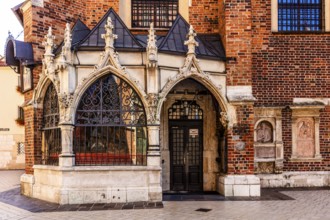 Entrance to St. Barbara Church, porch showing ornate Gothic stone carvings and wrought iron bars,