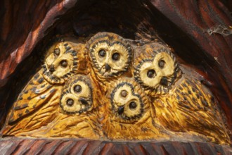 Close-up of birds of prey wood carving sculpture depicting a family of Tyto - Barn Owls by artist