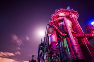 Violet-lit industrial building under bright night sky, Landschaftspark Duisburg Nord, Duisburg,